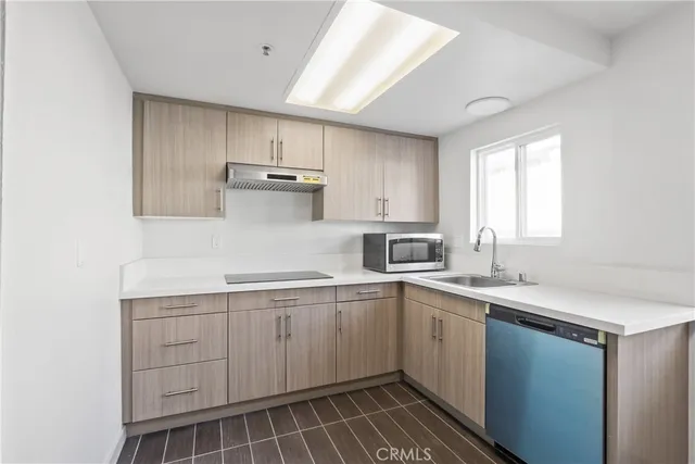 a kitchen with a refrigerator sink and cabinets
