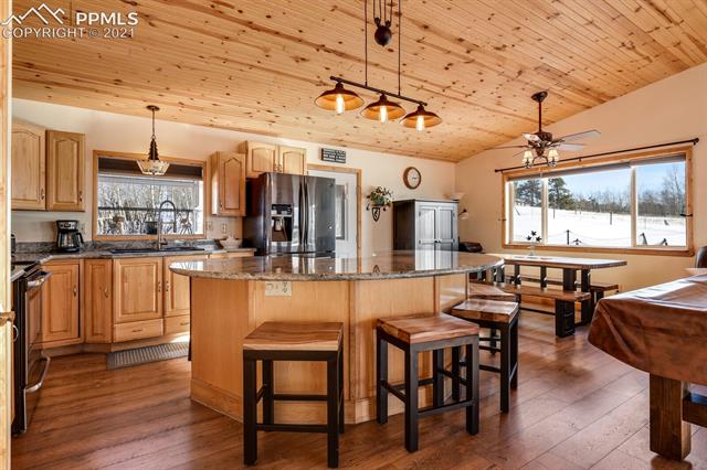 78 Ridge Top Drive Divide, CO 80814 - Photo 2 of 46 The kitchen area is inviting, beautiful and warm. There's a pantry, french door refrigerator with double freezer drawers below, garden window, custom granite countertops and cabinetry. Wood floors and ceilings finish off the look.