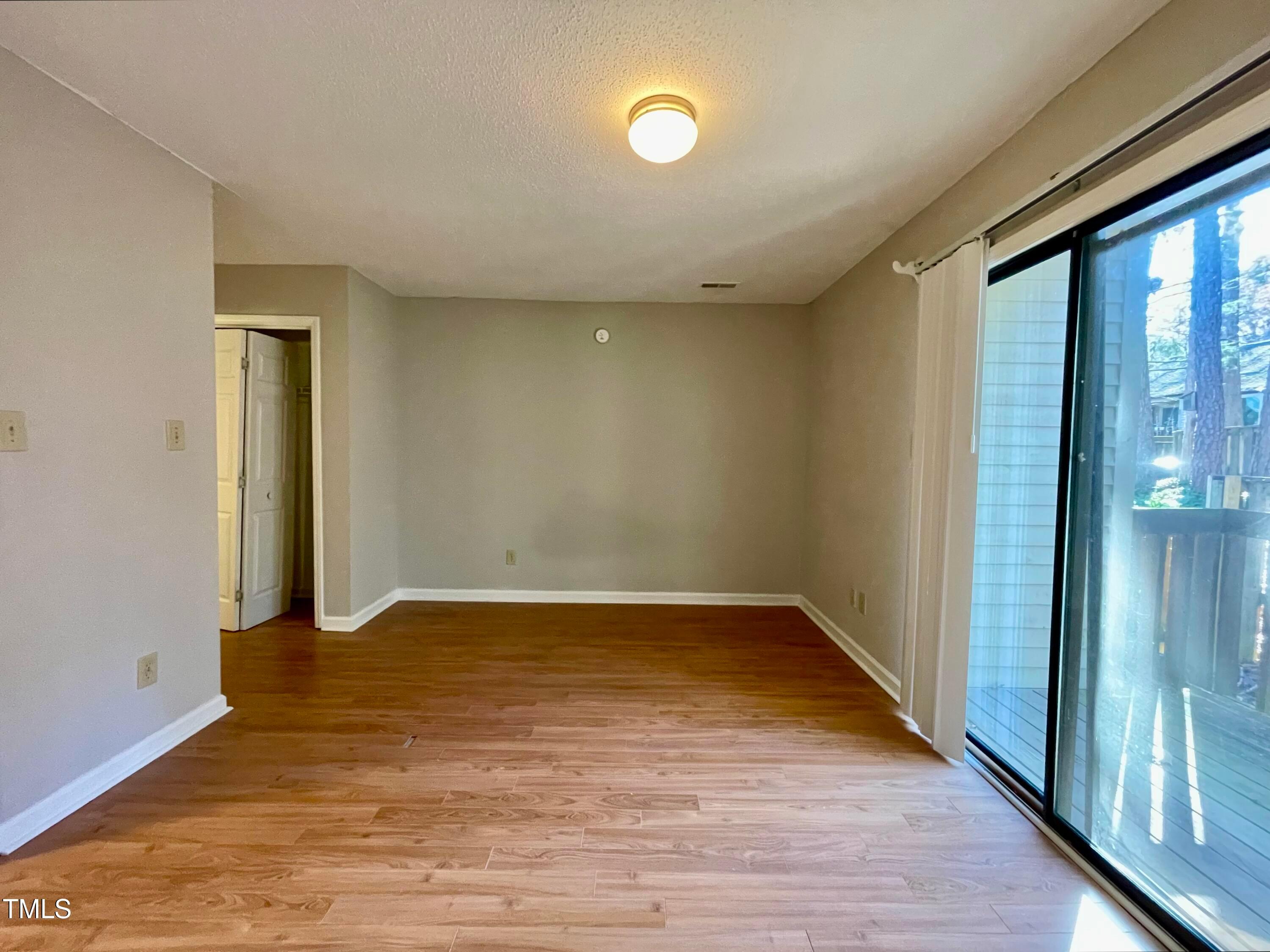 4114 Beechnut Lane Durham, NC 27707 - Photo 17 of 25 a view of an empty room with wooden floor and a window
