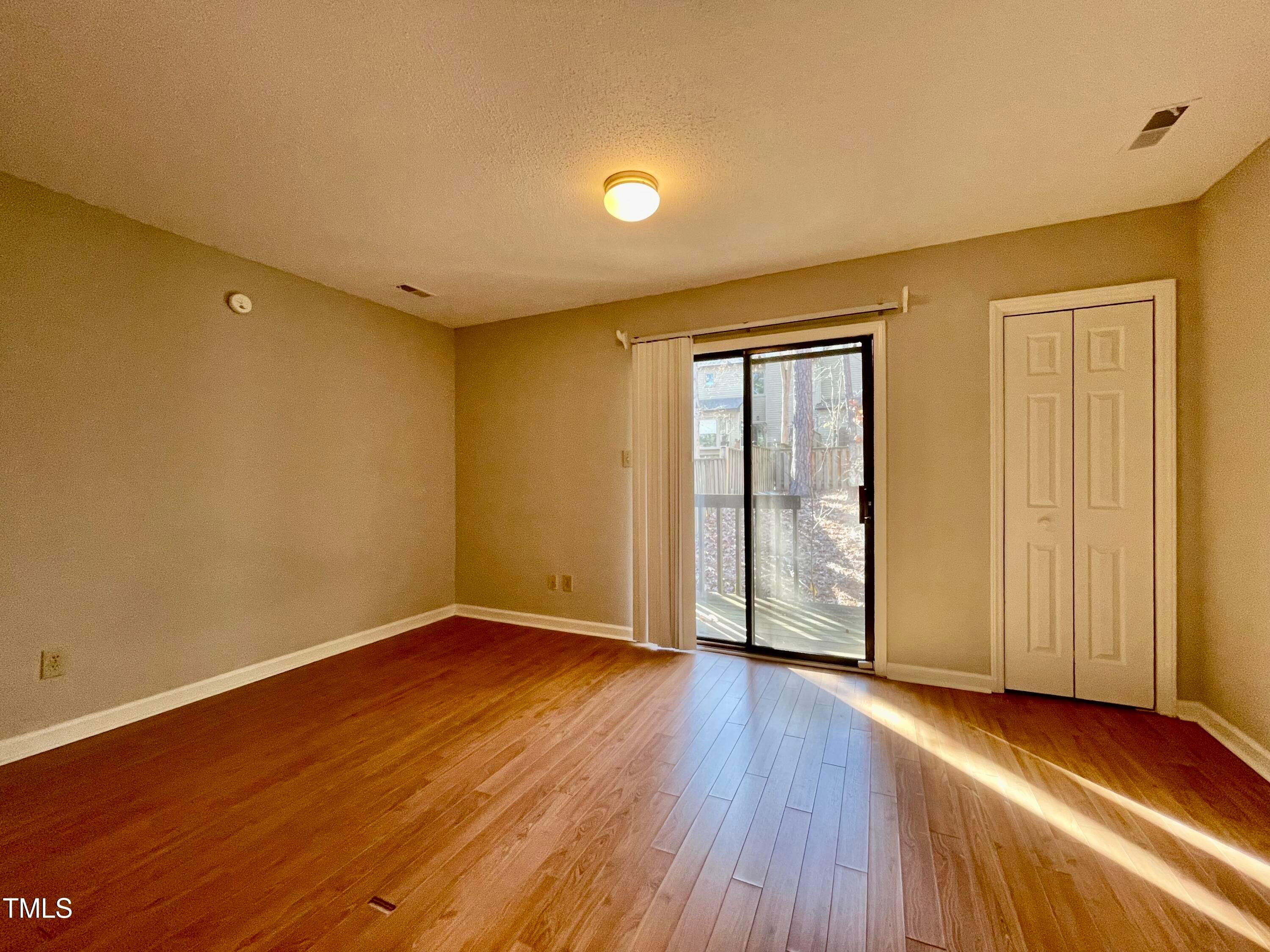 4114 Beechnut Lane Durham, NC 27707 - Photo 18 of 25 an empty room with wooden floor and windows