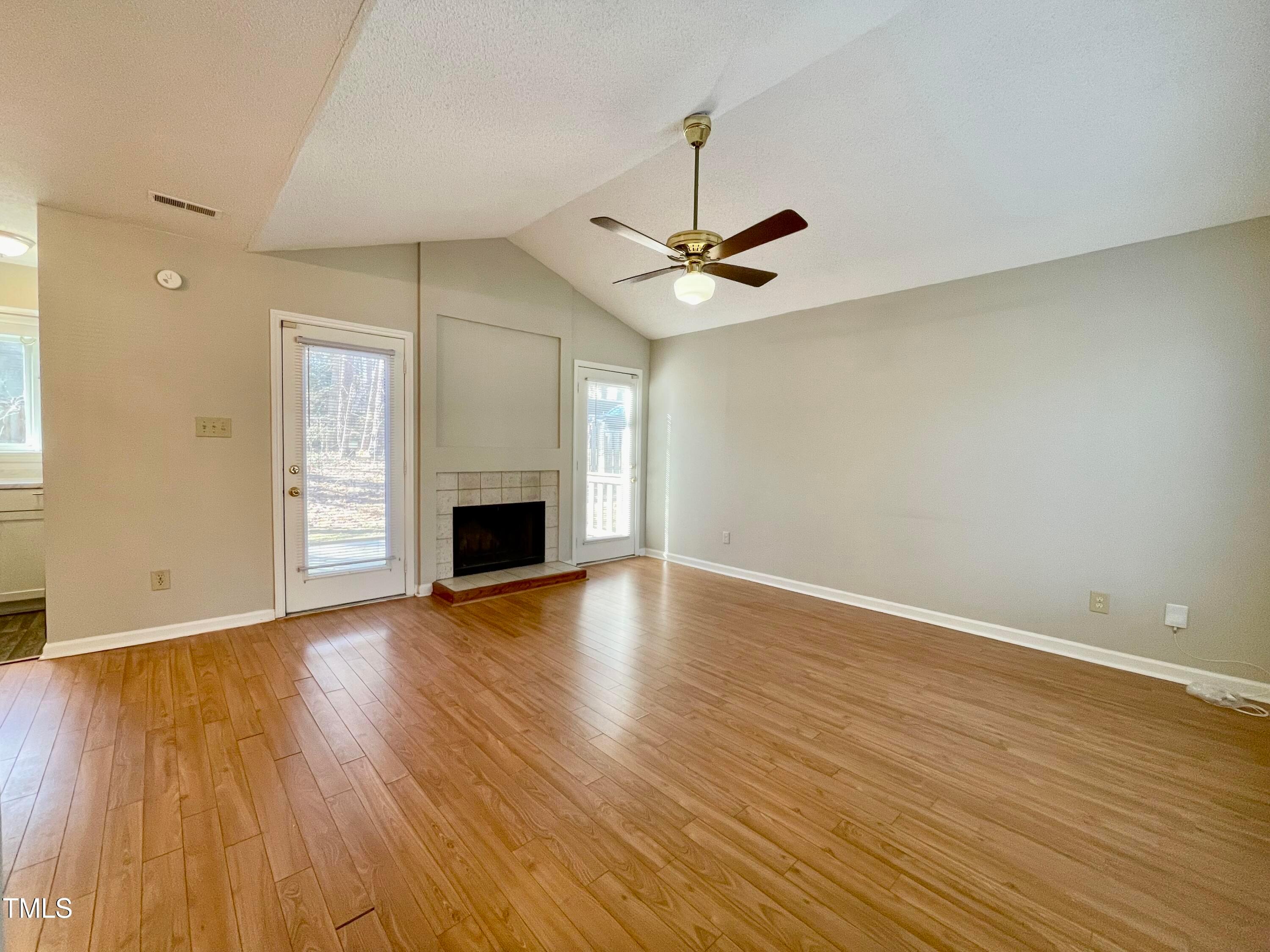4114 Beechnut Lane Durham, NC 27707 - Photo 2 of 25 an empty room with wooden floor fan and windows