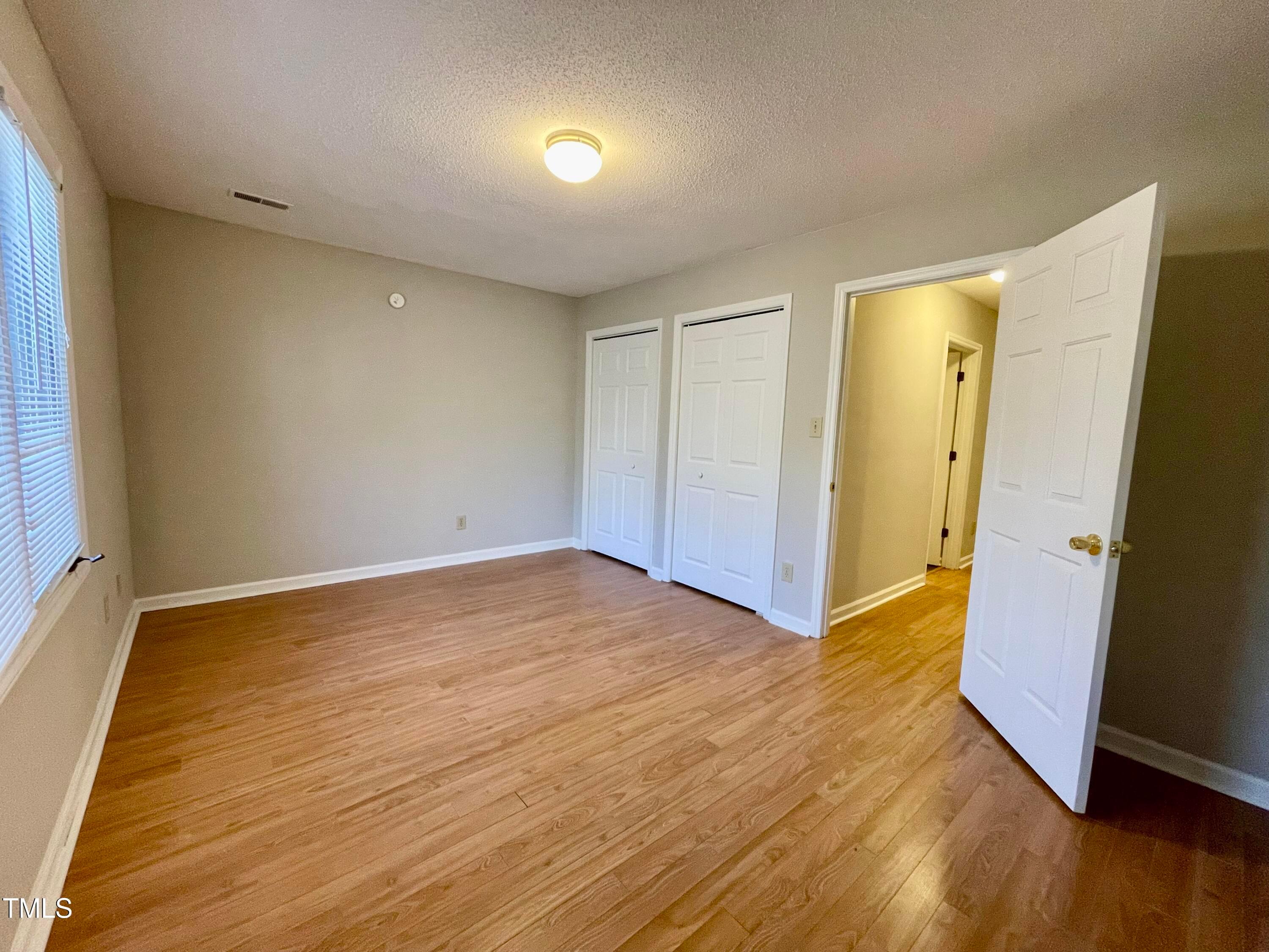 4114 Beechnut Lane Durham, NC 27707 - Photo 21 of 25 a view of an empty room with wooden floor and a bathroom