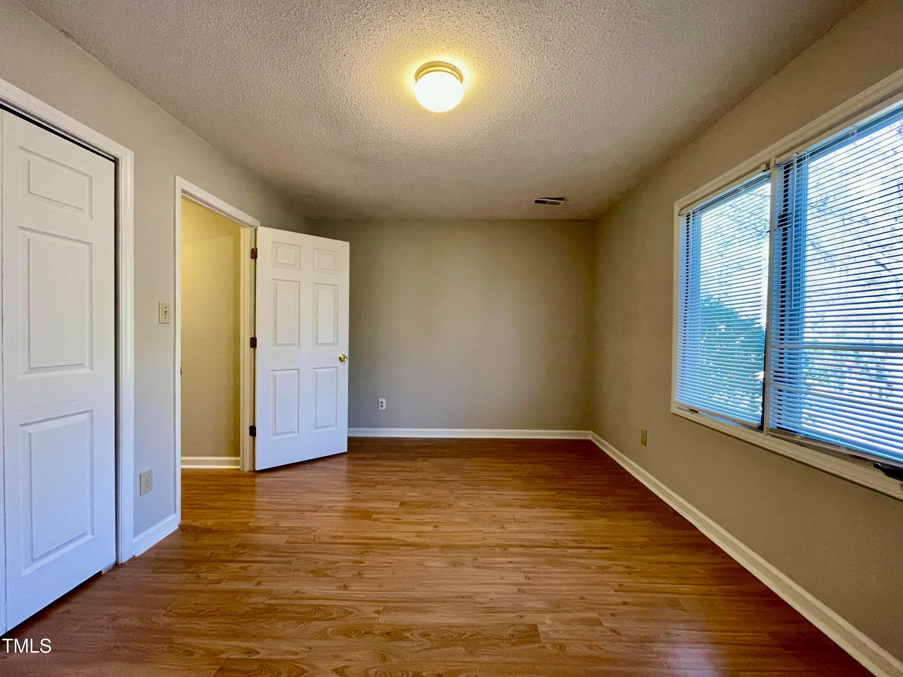 4114 Beechnut Lane Durham, NC 27707 - Photo 22 of 25 an empty room with wooden floor and windows