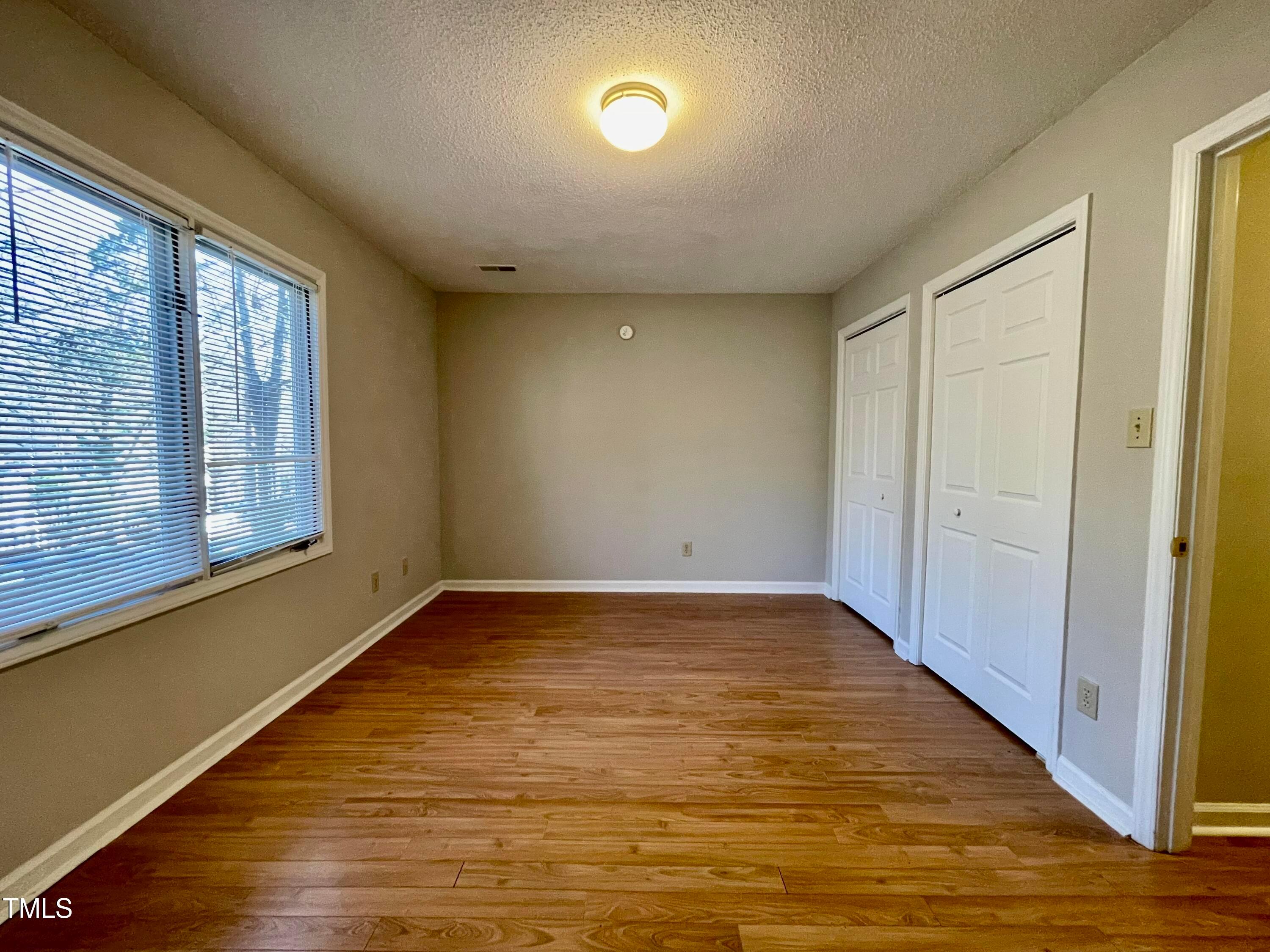 4114 Beechnut Lane Durham, NC 27707 - Photo 23 of 25 a view of an empty room with wooden floor and a window