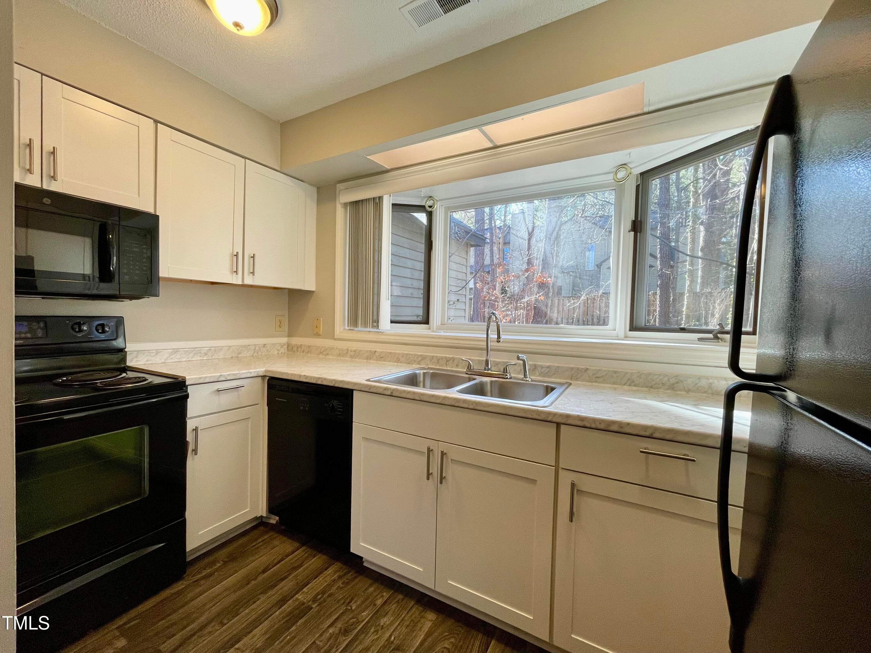 4114 Beechnut Lane Durham, NC 27707 - Photo 9 of 25 a kitchen with a sink stove and microwave