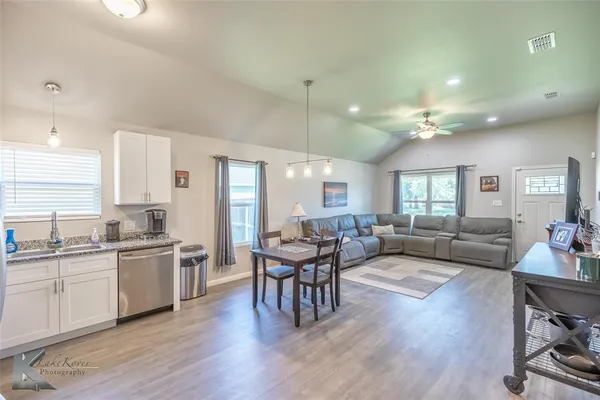 a living room with lots of furniture and view of kitchen