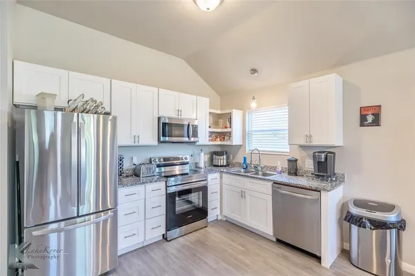 a kitchen with stainless steel appliances a refrigerator sink and microwave