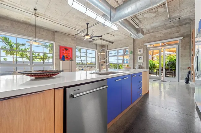a kitchen with stainless steel appliances kitchen island granite countertop a refrigerator and a sink