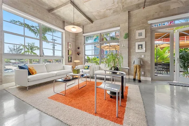 a living room with patio furniture and a large window