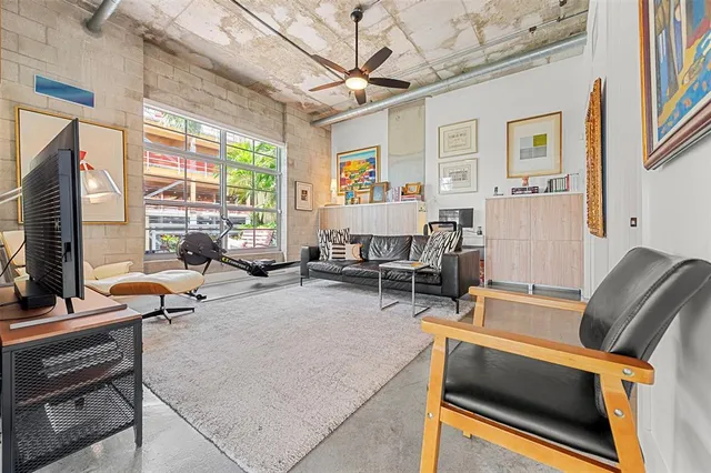 a living room with furniture a flat screen tv and a window