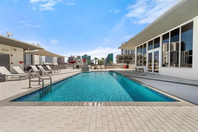 a view of a house with pool and chairs