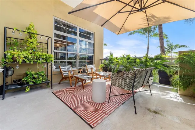 a view of a patio with a table and chairs under an umbrella