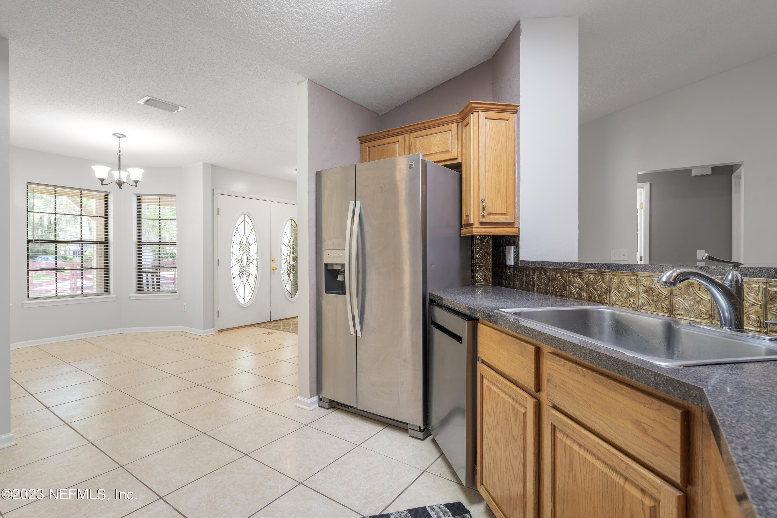 870 Fleming Street Fleming Island, FL 32003 - Photo 12 of 48 a kitchen with stainless steel appliances granite countertop a refrigerator and a sink