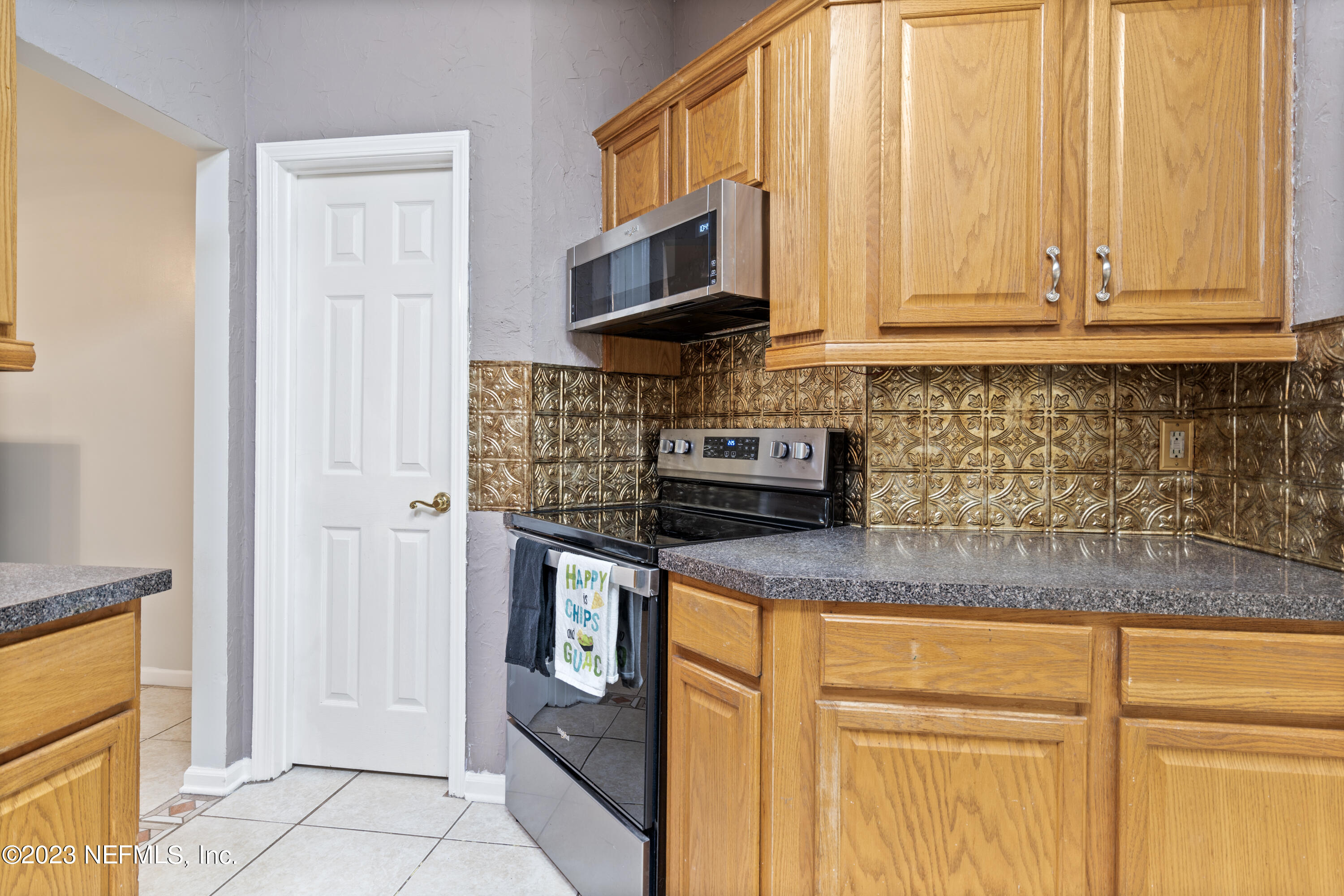 870 Fleming Street Fleming Island, FL 32003 - Photo 14 of 48 a kitchen with stainless steel appliances granite countertop a stove a sink and a microwave