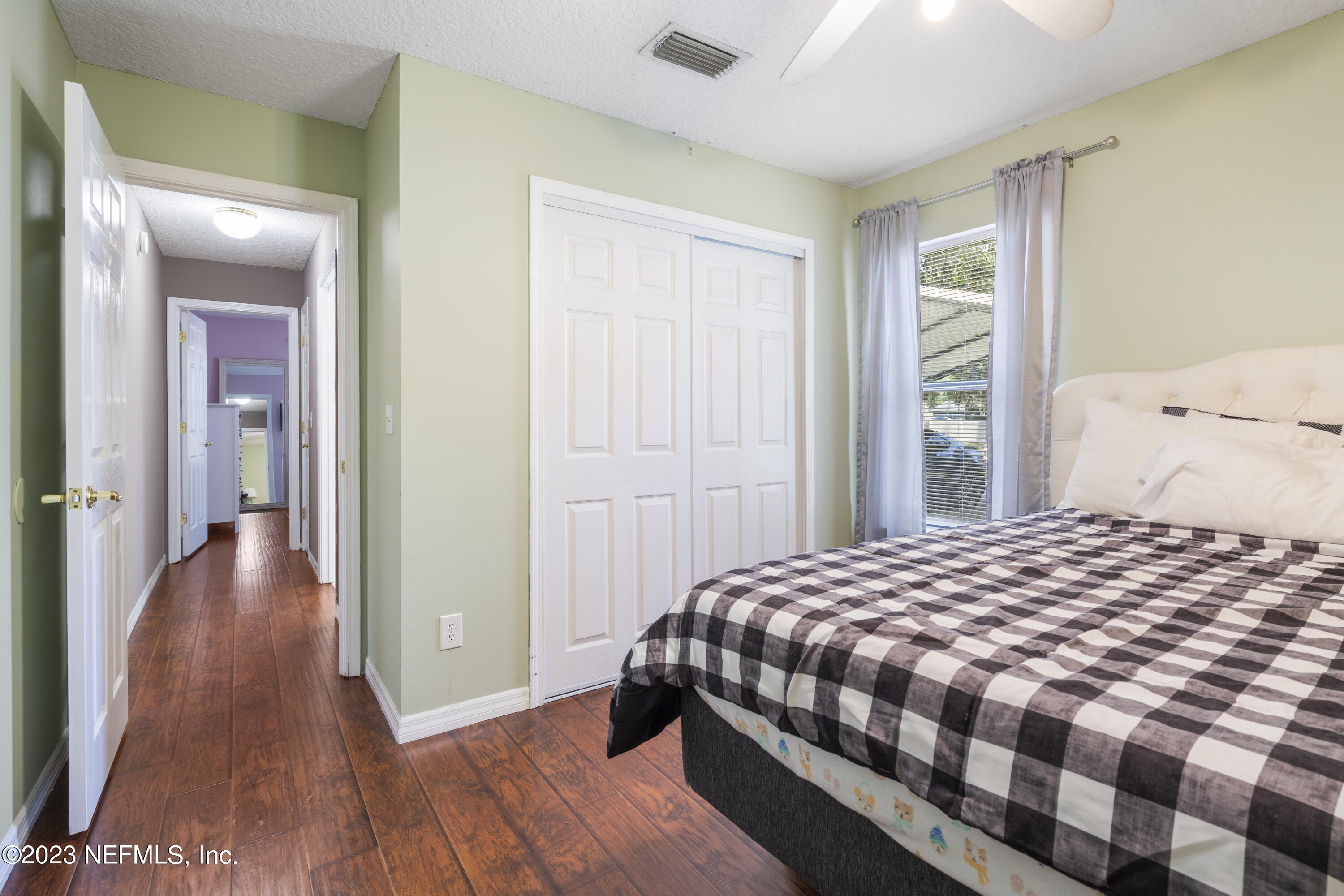 870 Fleming Street Fleming Island, FL 32003 - Photo 18 of 48 a bedroom with a bed and wooden floor