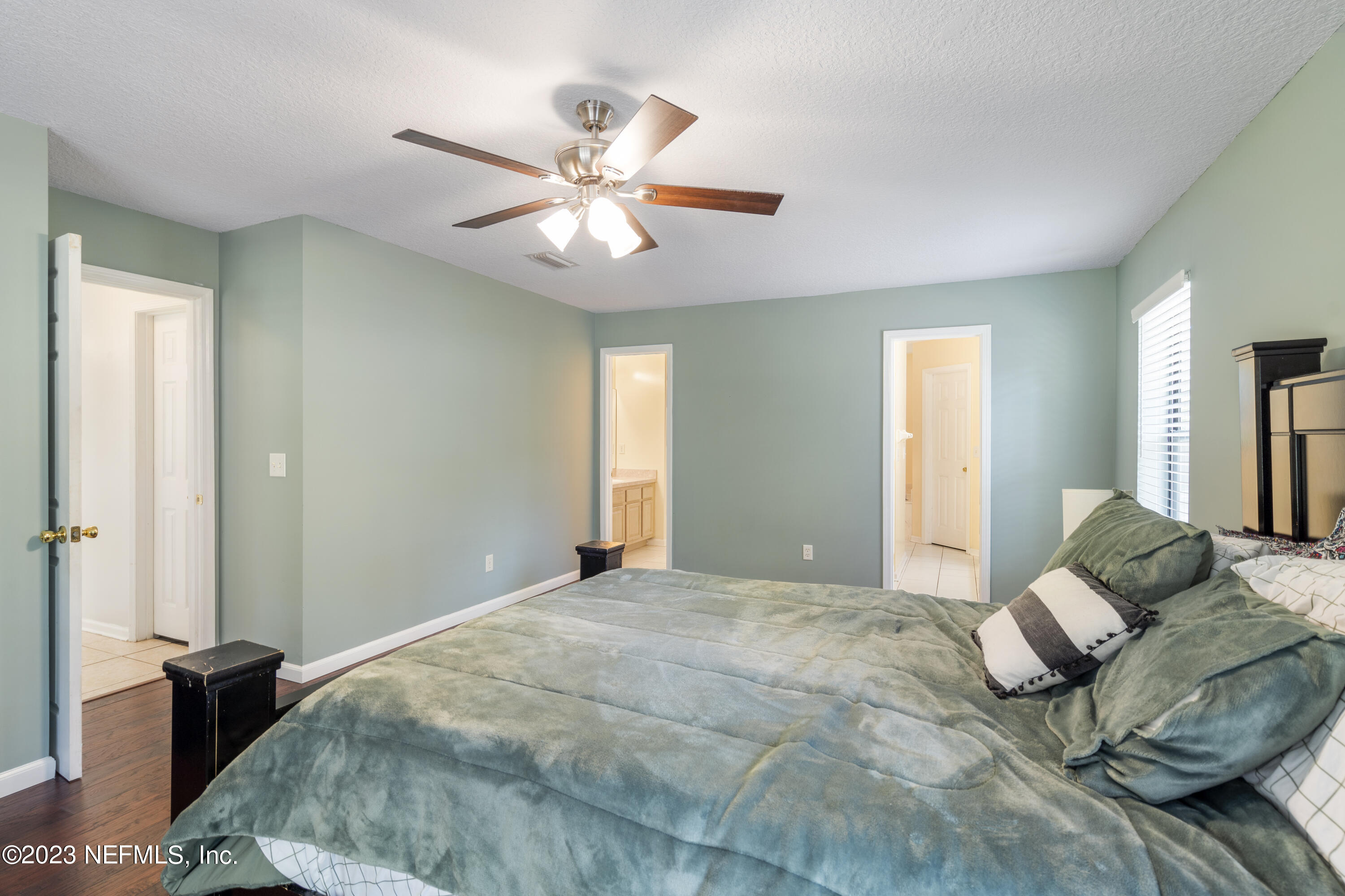 870 Fleming Street Fleming Island, FL 32003 - Photo 27 of 48 a bedroom with a large bed and a chandelier