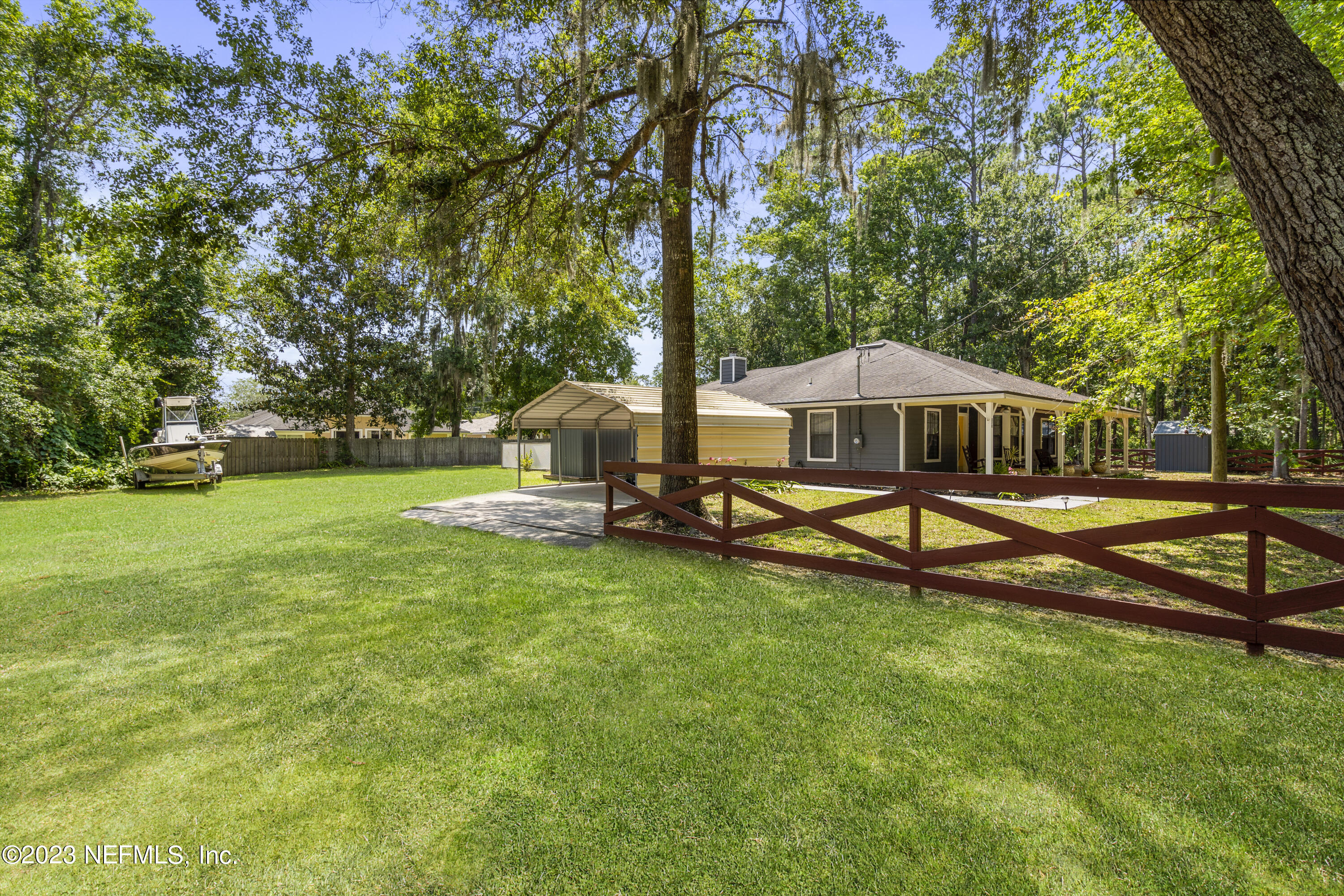 870 Fleming Street Fleming Island, FL 32003 - Photo 31 of 48 a view of a swimming pool with lawn chairs under an umbrella