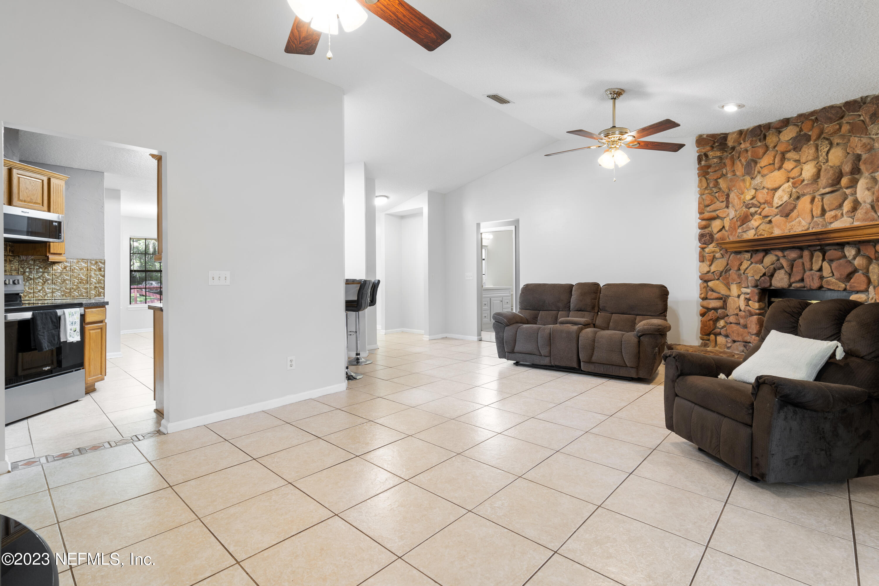 870 Fleming Street Fleming Island, FL 32003 - Photo 9 of 48 a living room with furniture and a chandelier