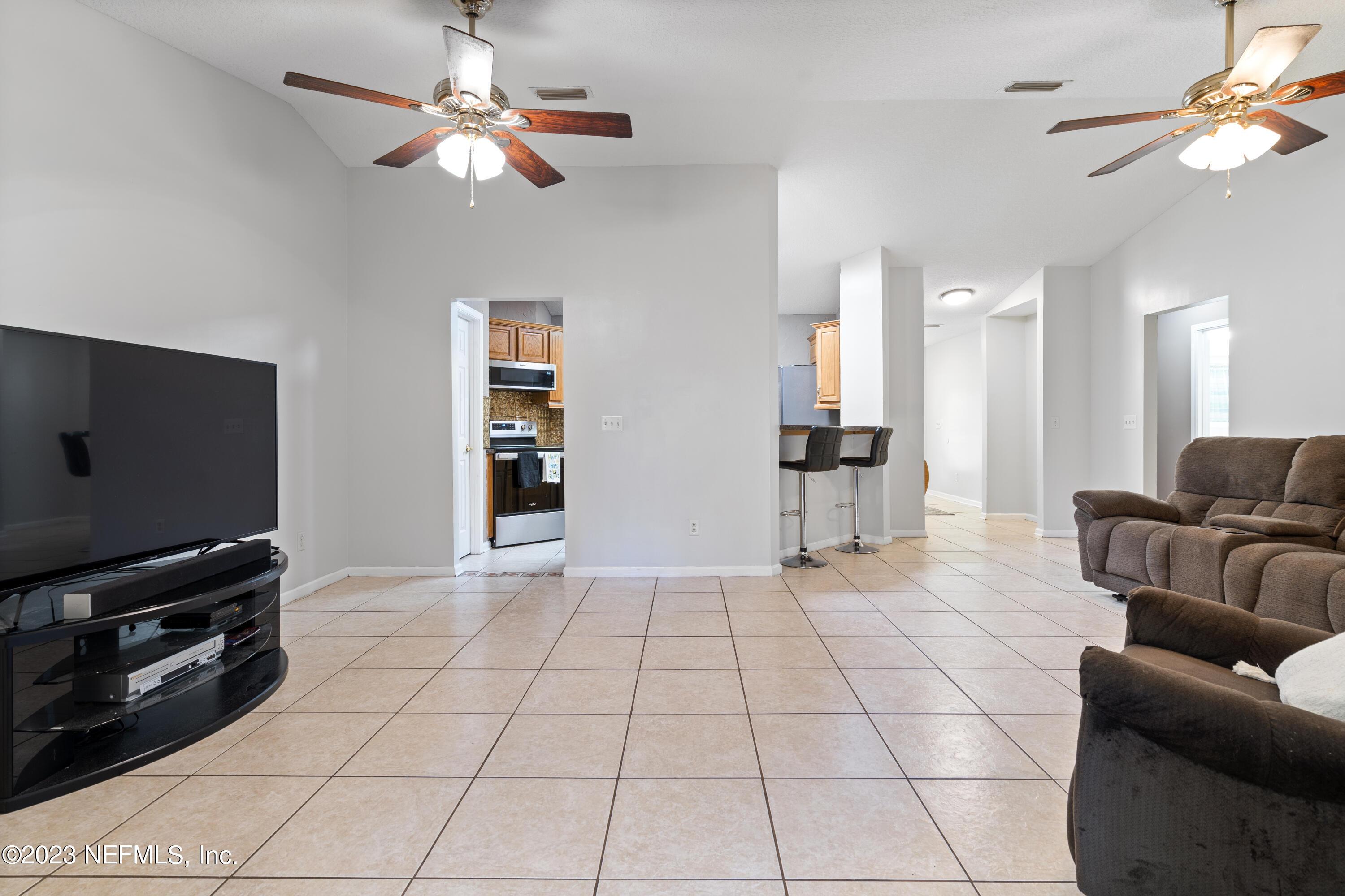 870 Fleming Street Fleming Island, FL 32003 - Photo 10 of 48 a living room with furniture and a flat screen tv