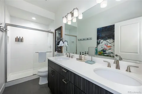 a bathroom with a double vanity sink mirror and toilet