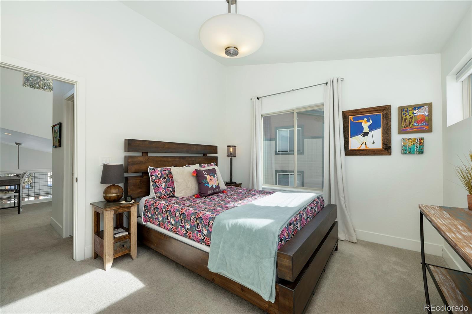 40 Journey Way Fraser, CO 80442 - Photo 21 of 41 a bedroom with a large bed and a chandelier