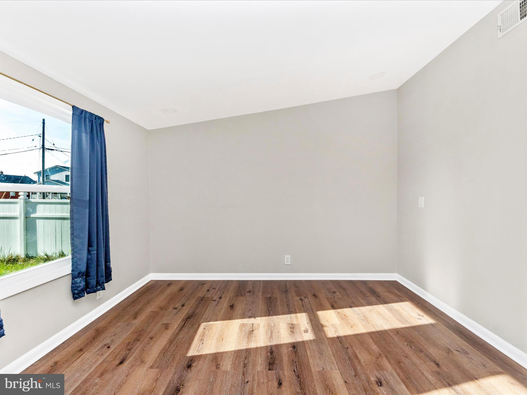 1203 North Point Road Dundalk, MD 21222 - Photo 25 of 42 an empty room with wooden floor and windows
