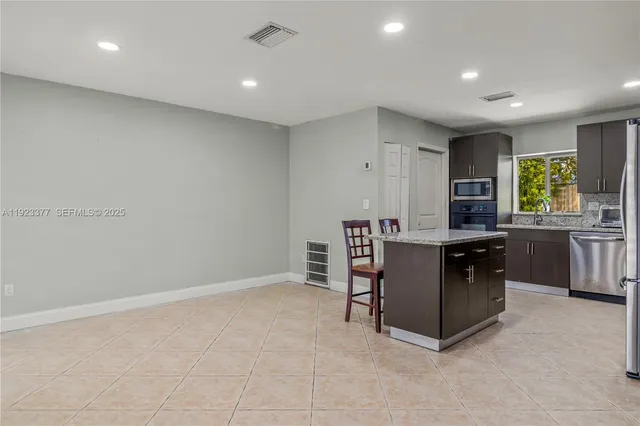 a kitchen with cabinets and chairs