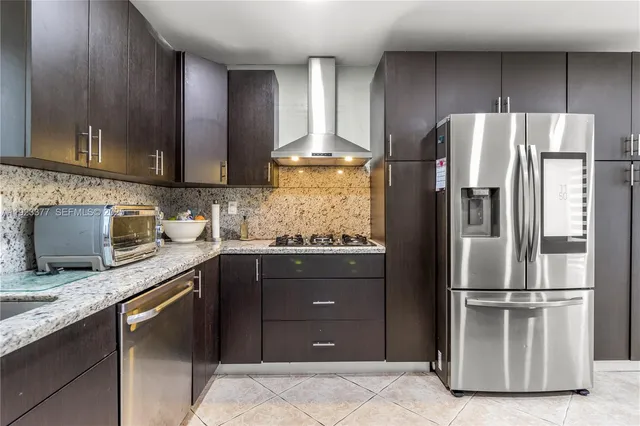 a kitchen with granite countertop stainless steel appliances and wooden cabinets