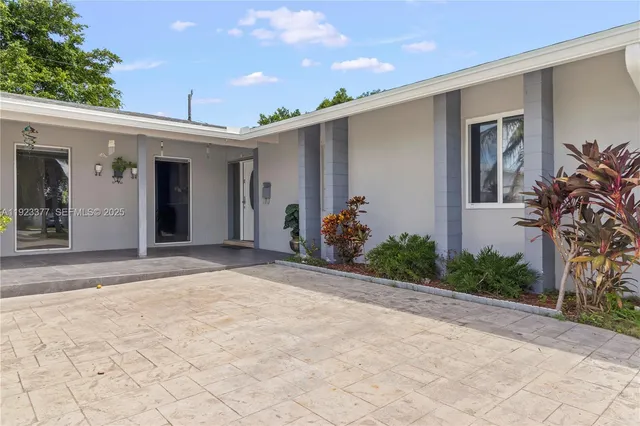 a view of a house with a backyard and plants
