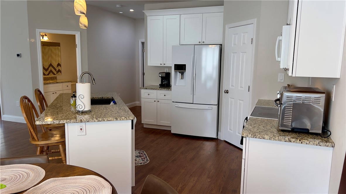 160 Hudgins Lake Road Townville, SC 29689 - Photo 33 of 41 A well-appointed kitchen features a central island, granite countertops, and rich hardwood flooring.