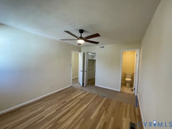 a view of a livingroom with wooden floor and a ceiling fan