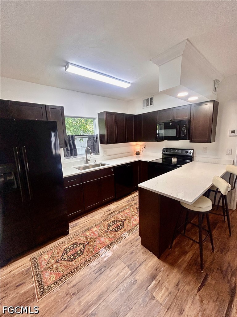 a kitchen with stainless steel appliances kitchen island granite countertop a sink dishwasher stove and refrigerator with wooden floor