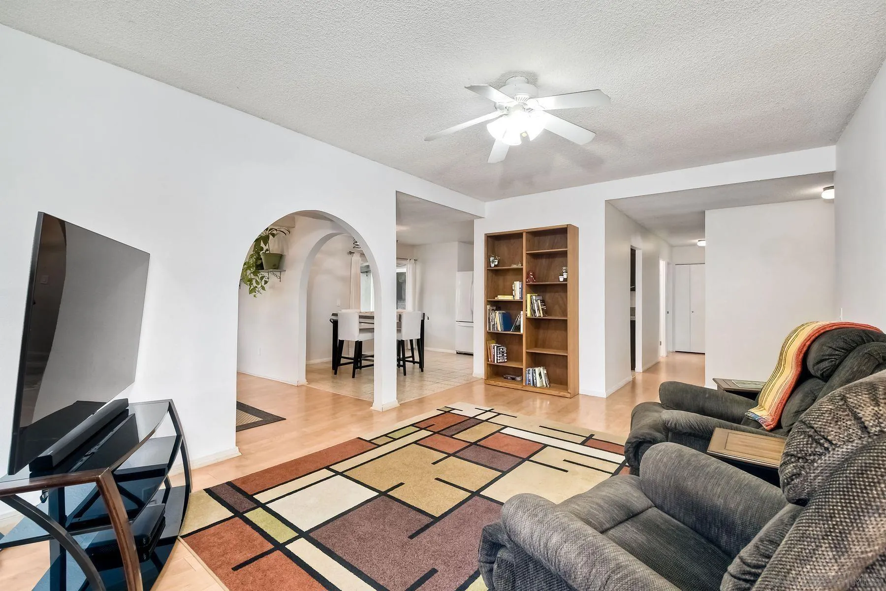 14051 Olive Meadows Place Poway, CA 92064 - Photo 7 of 33 a living room with furniture a table and a flat screen tv