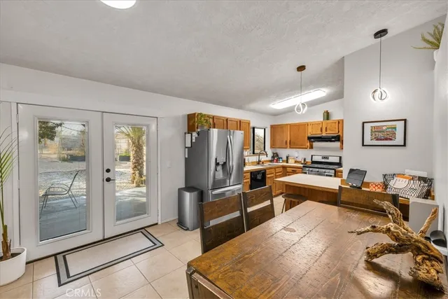 a kitchen with stainless steel appliances granite countertop a refrigerator and a stove top oven