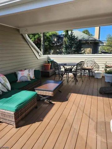 a view of a patio with dining table and chairs with wooden floor and fence