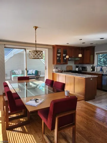 a living room with stainless steel appliances kitchen island granite countertop furniture and a wooden floor
