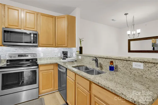 a kitchen with stainless steel appliances granite countertop a sink stove and microwave