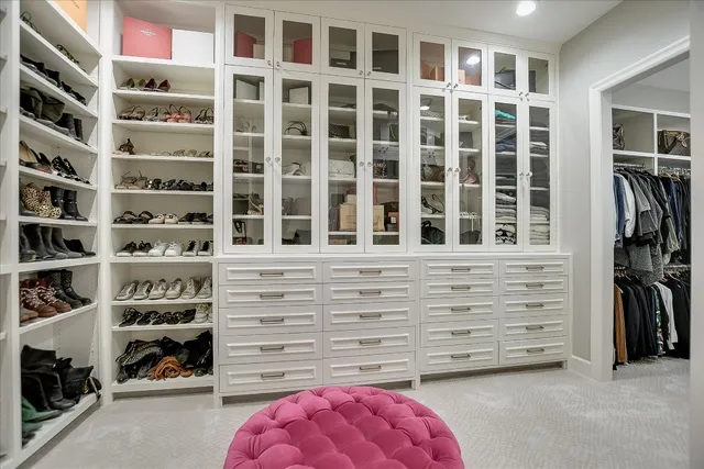 a view of walk in closet with clothes and shoes