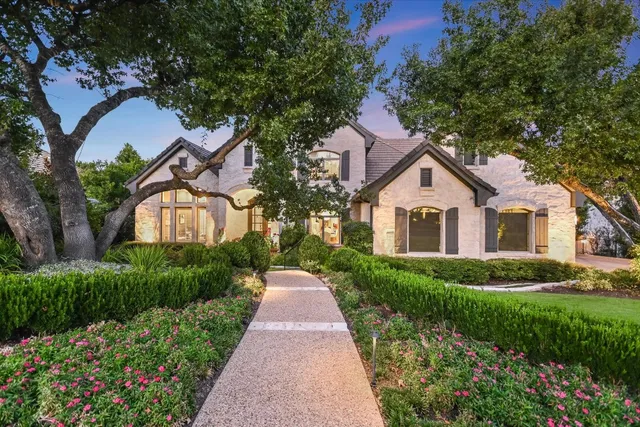 a front view of a house with a yard and trees