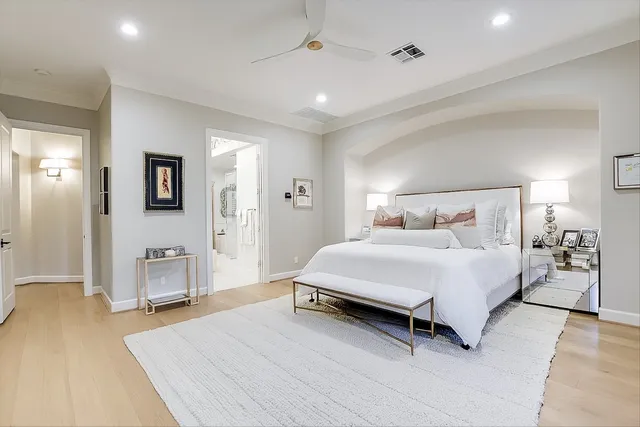 a spacious bedroom with a bed and dresser