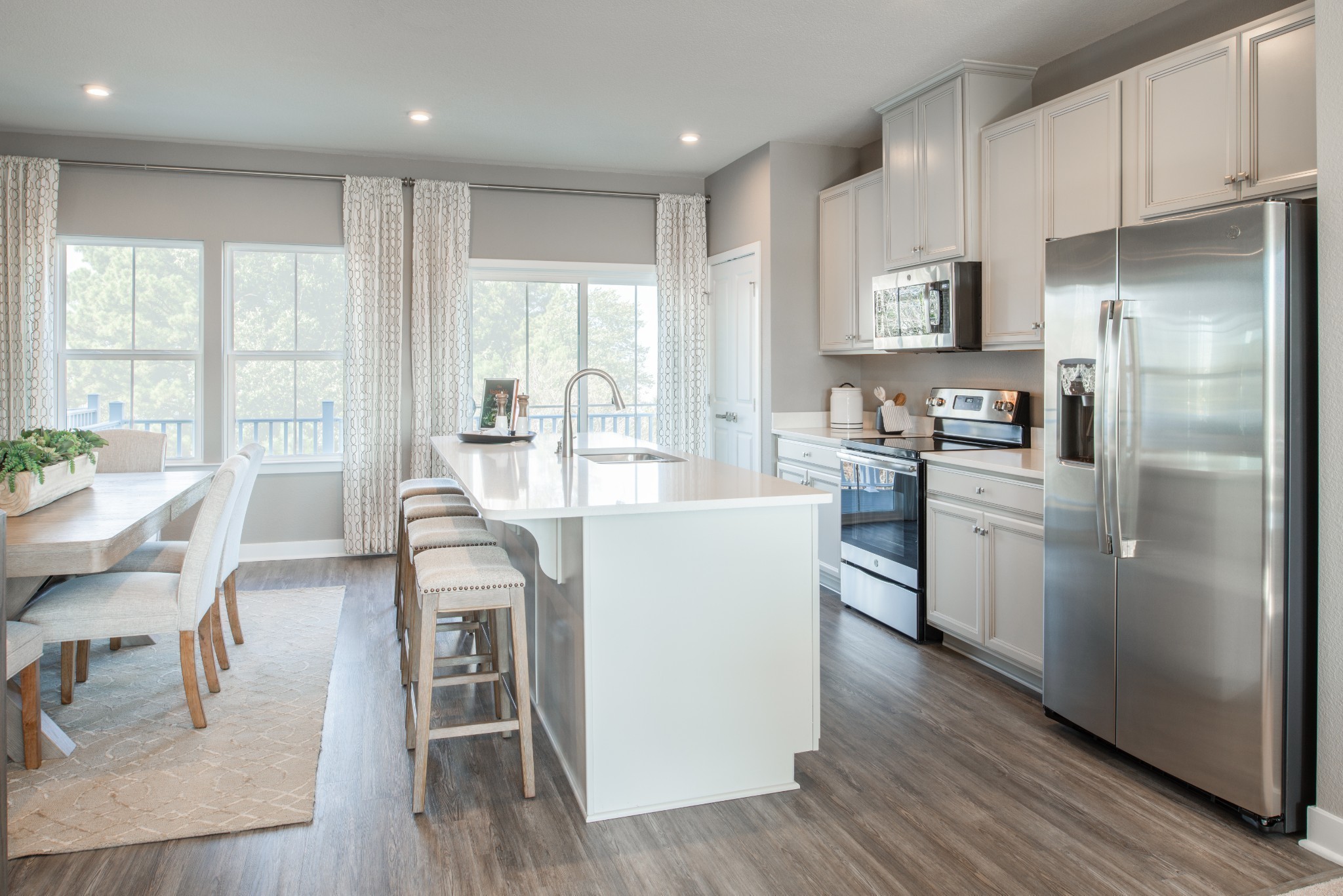 322 Poplar Loop Antioch, TN 37013 - Photo 4 of 20 a kitchen with stainless steel appliances granite countertop a stove a sink a refrigerator and white cabinets with wooden floor