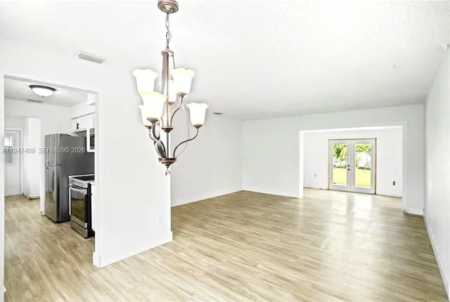 a view of a room with wooden floor and ceiling fan