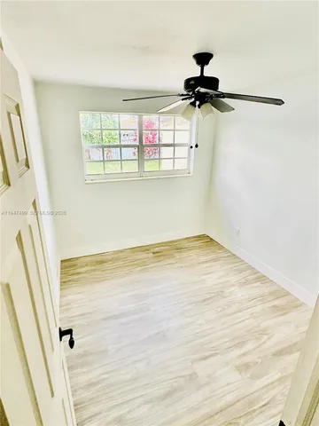 a view of a room with wooden floor and window