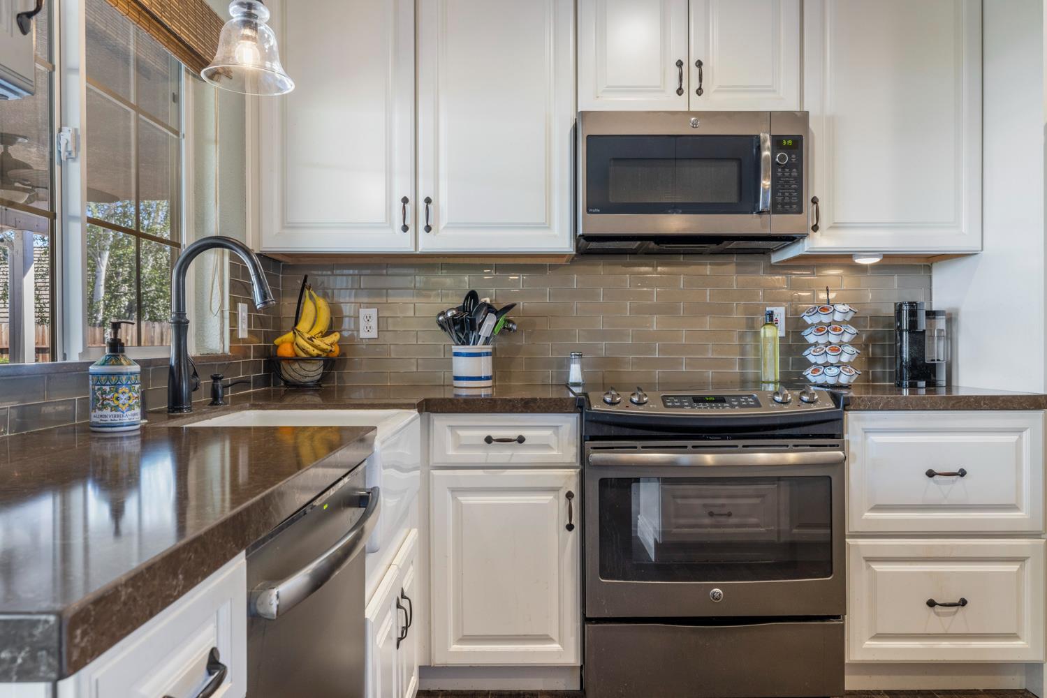 1084 Eastburg Court Ripon, CA 95366 - Photo 12 of 46 a kitchen with stainless steel appliances granite countertop white cabinets a stove top oven and granite counter tops