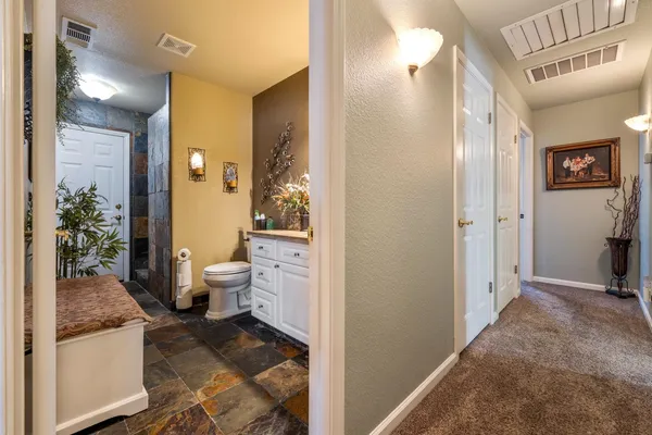 a bathroom with a granite countertop toilet a sink and a mirror