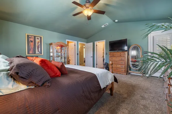 a bedroom with a bed a ceiling fan and a dresser
