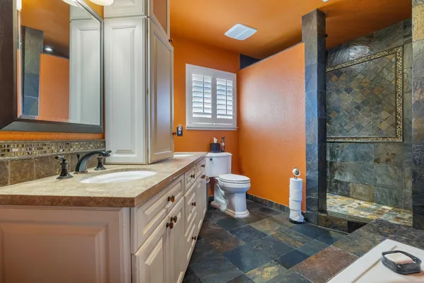 a bathroom with a granite countertop sink and a mirror