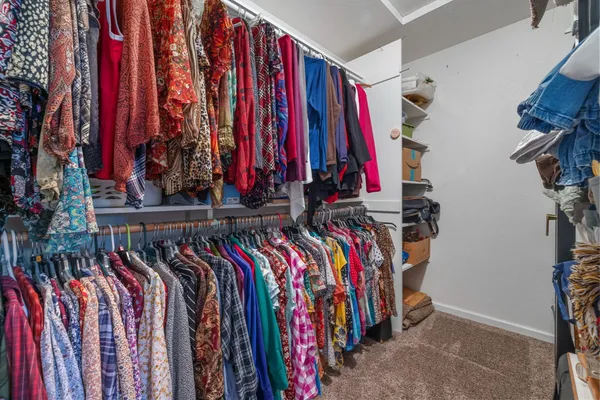 a view of walk in closet with clothes