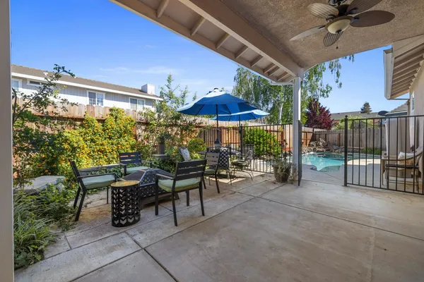 a view of a patio with a table and chairs under an umbrella