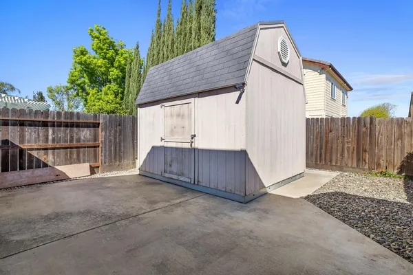 a view of backyard with small tub and wooden fence